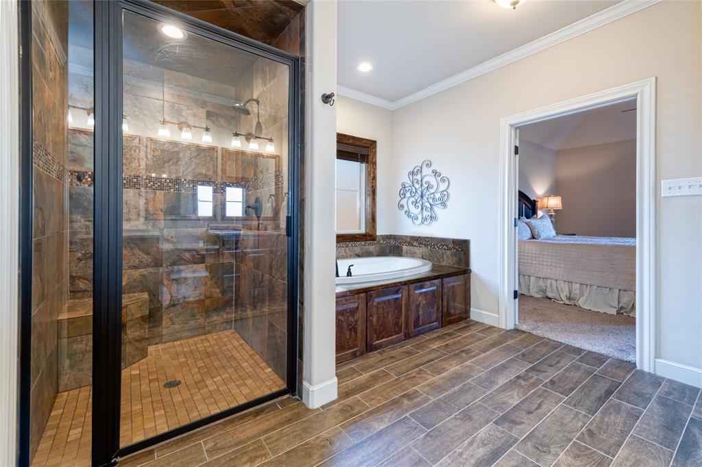 266 Weatherby Street Tuscola, TX 79562 - Photo 16 of 29 Ensuite bathroom featuring wood tiled floors, ornamental molding, a bath, and a shower stall