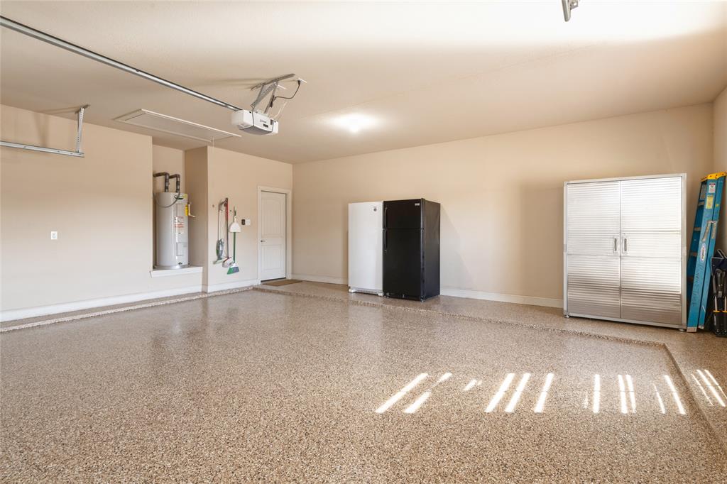 266 Weatherby Street Tuscola, TX 79562 - Photo 26 of 29 Garage with freestanding refrigerator, electric water heater, and a garage door opener
