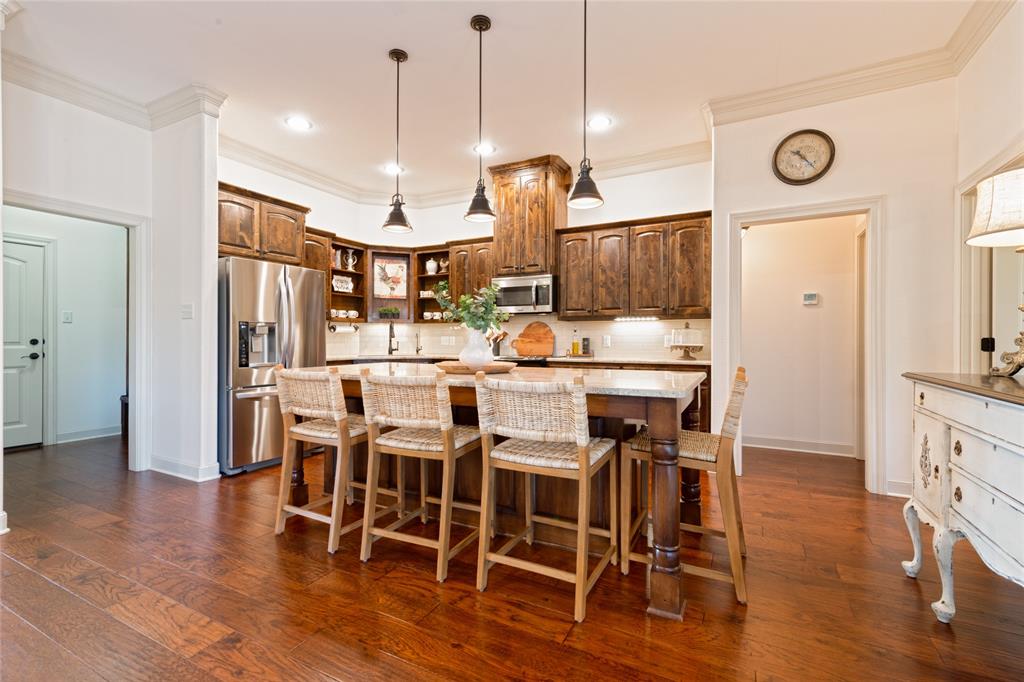 266 Weatherby Street Tuscola, TX 79562 - Photo 9 of 29 Kitchen with pendant lighting, stainless steel appliances, a kitchen island, dark wood-type flooring, and ornamental molding
