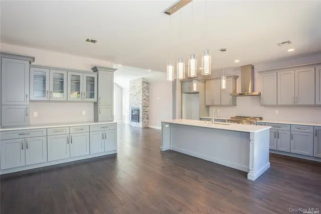 a large kitchen with kitchen island a sink wooden floor and white stainless steel appliances