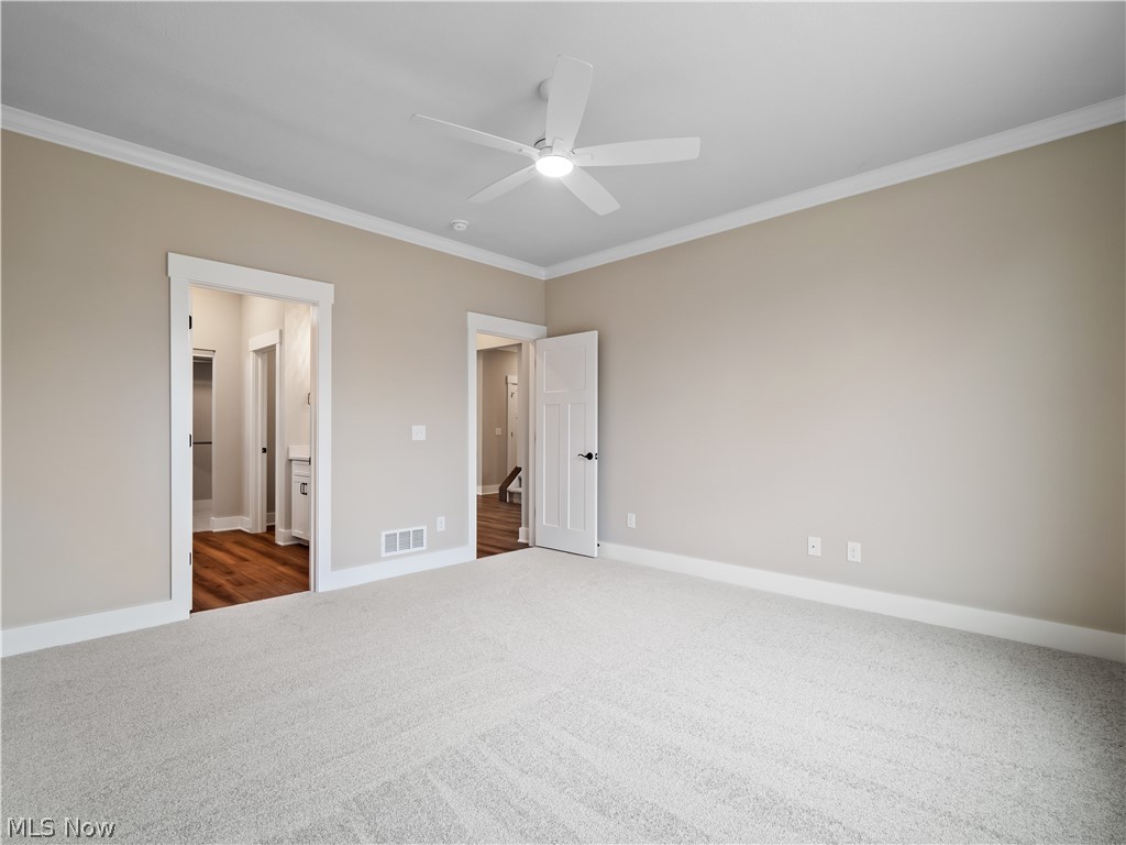 34270 Brookside Lane North Ridgeville, OH 44039 - Photo 27 of 50 Unfurnished bedroom with crown molding, dark colored carpet, ceiling fan, and ensuite bathroom
