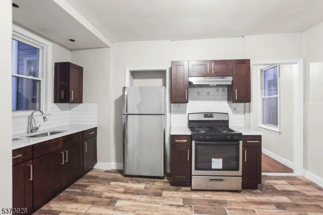 a kitchen with stainless steel appliances granite countertop a refrigerator and a sink