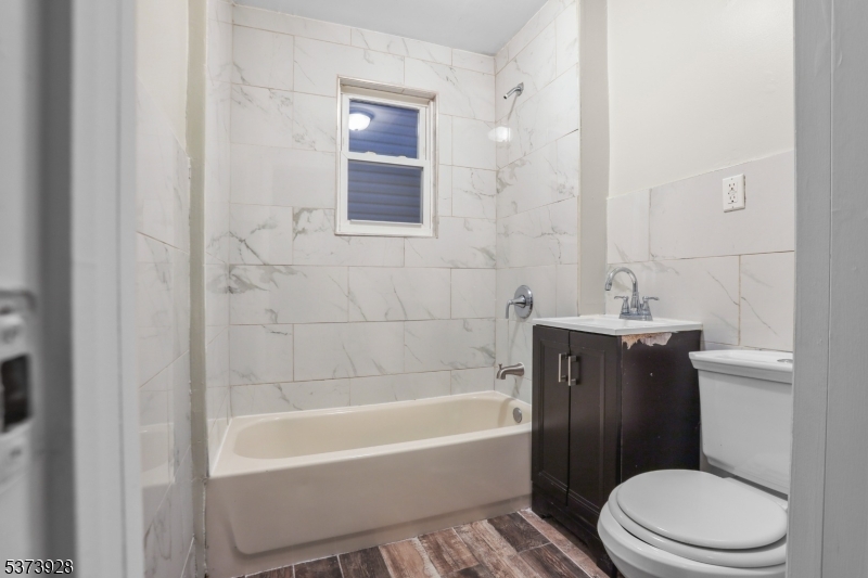 79 Irving Street Newark, NJ 07104 - Photo 15 of 30 a bathroom with a sink a toilet and bathtub