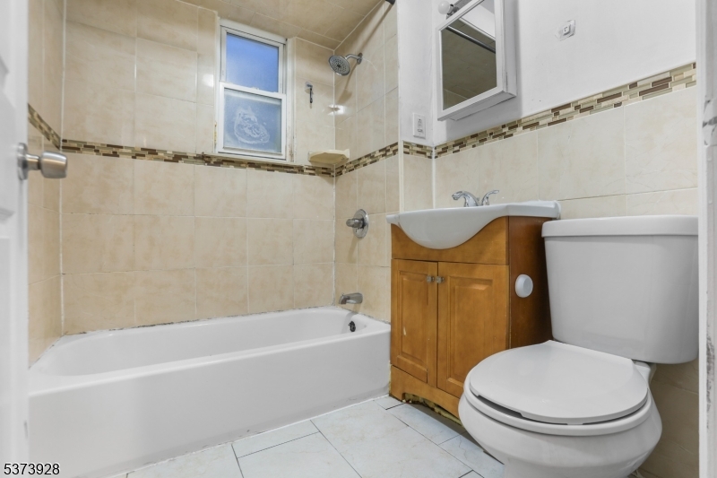 79 Irving Street Newark, NJ 07104 - Photo 16 of 30 a bathroom with a sink a mirror toilet and bathtub