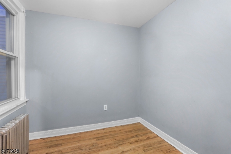 79 Irving Street Newark, NJ 07104 - Photo 23 of 30 a view of an empty room with wooden floor and a window