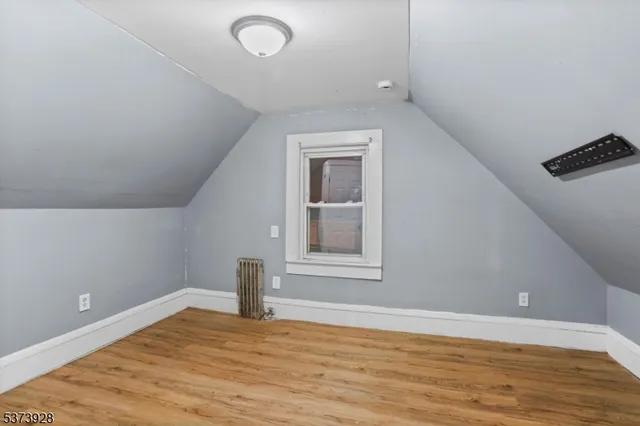a view of a livingroom with wooden floor and a window