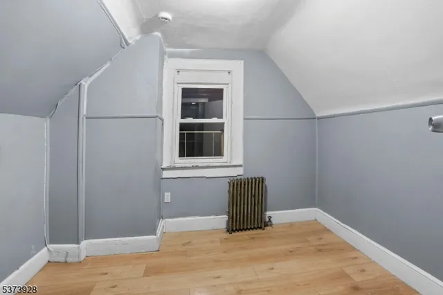 a view of empty room with wooden floor and cabinet
