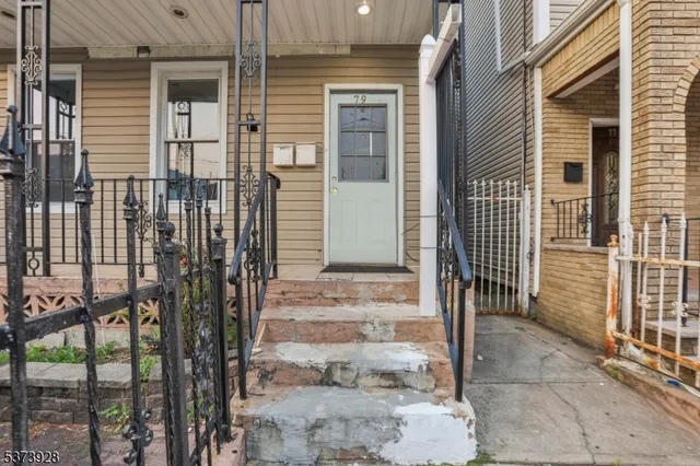 a view of a house with a door and wooden bench