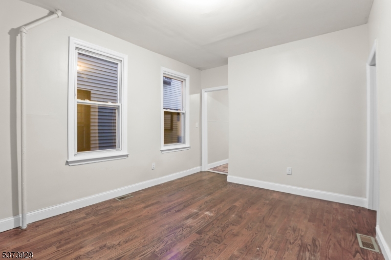 79 Irving Street Newark, NJ 07104 - Photo 8 of 30 a view of an empty room with wooden floor and a window