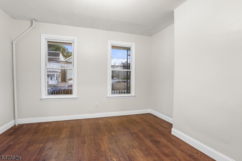 79 Irving Street Newark, NJ 07104 - Photo 10 of 30 an empty room with wooden floor and windows