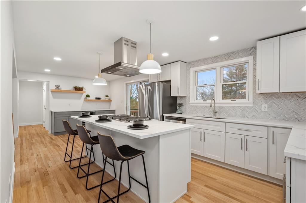 107 Marlboro Road Pittsburgh, PA 15238 - Photo 12 of 45 a kitchen with stainless steel appliances a white table chairs and a wooden floor