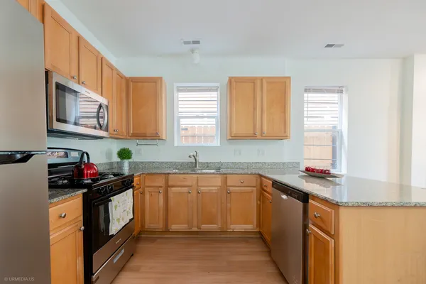 a kitchen with stainless steel appliances granite countertop a sink stove cabinets and a refrigerator