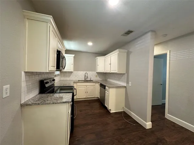 a kitchen with a sink stove and cabinets