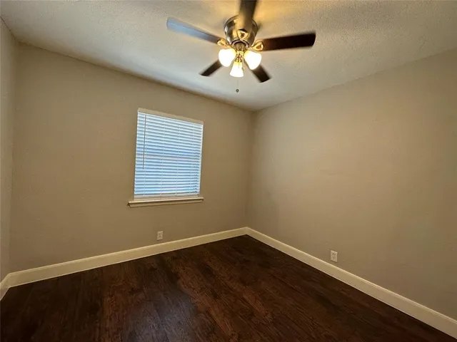 a view of a room with wooden floor and a ceiling fan