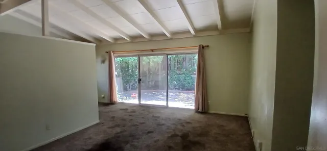 a view of hallway with wooden floor and flat screen tv