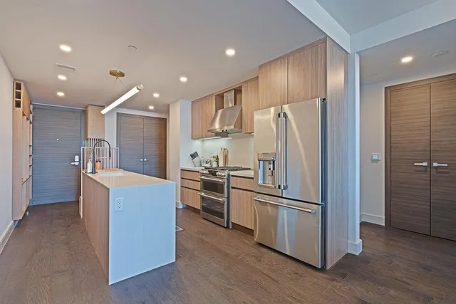 a kitchen with kitchen island wooden cabinets and stainless steel appliances
