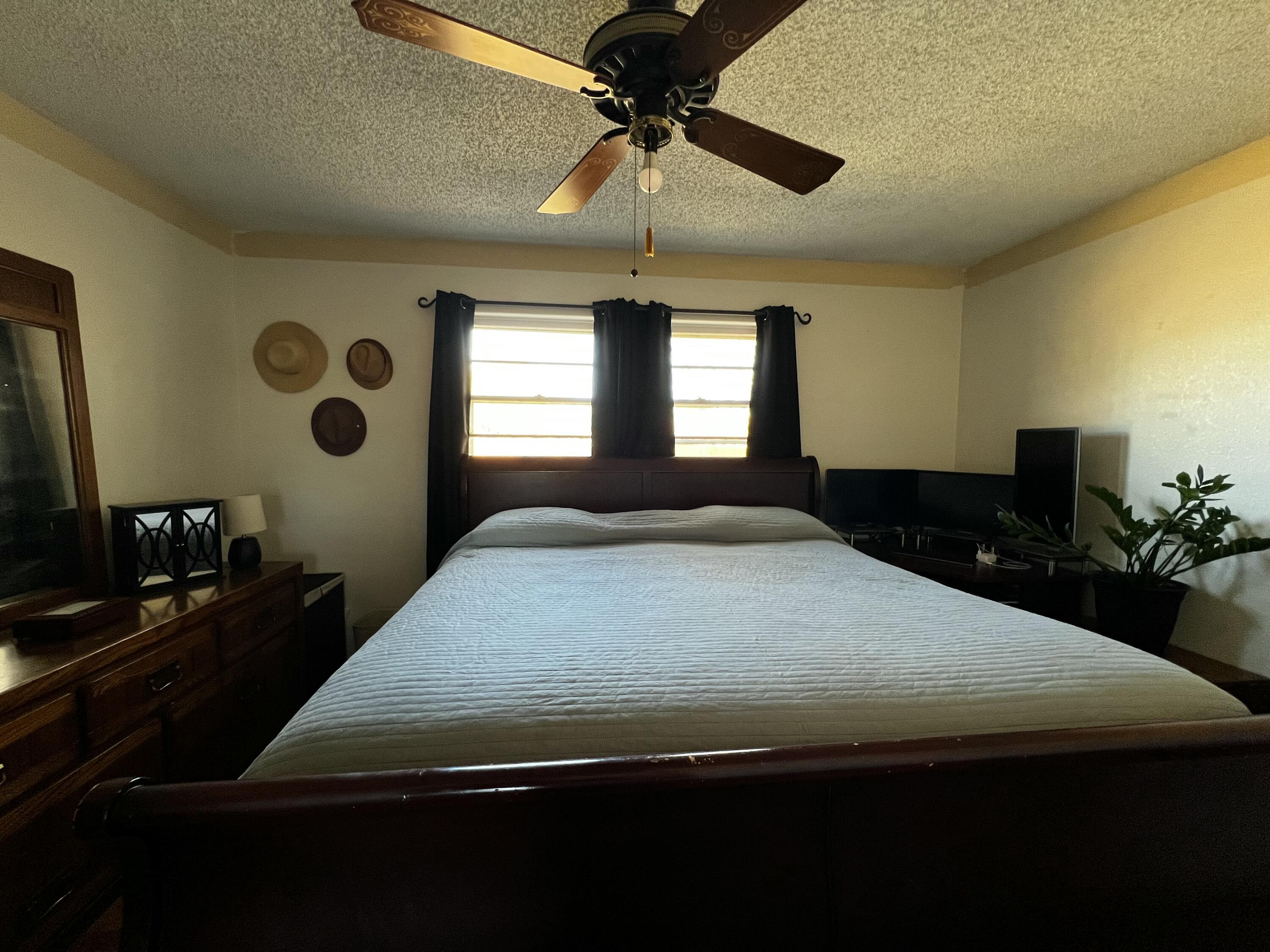 4520 36th Street Lubbock, TX 79414 - Photo 17 of 30 a bedroom with a bed and a chandelier