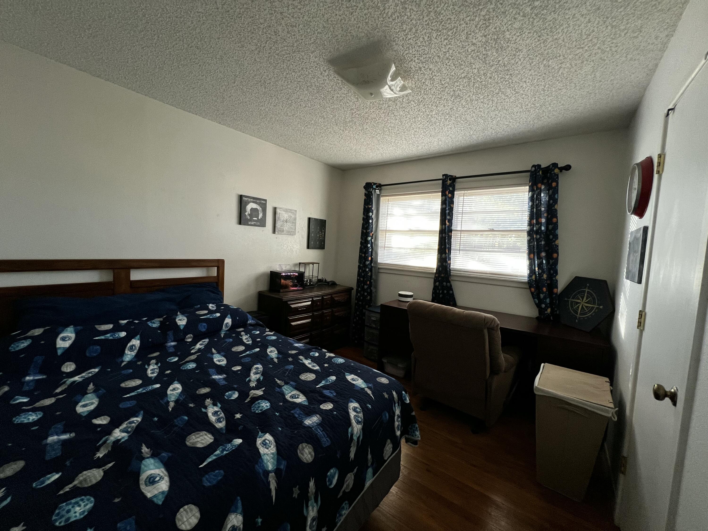 4520 36th Street Lubbock, TX 79414 - Photo 23 of 30 a bedroom with a bed and wooden floor