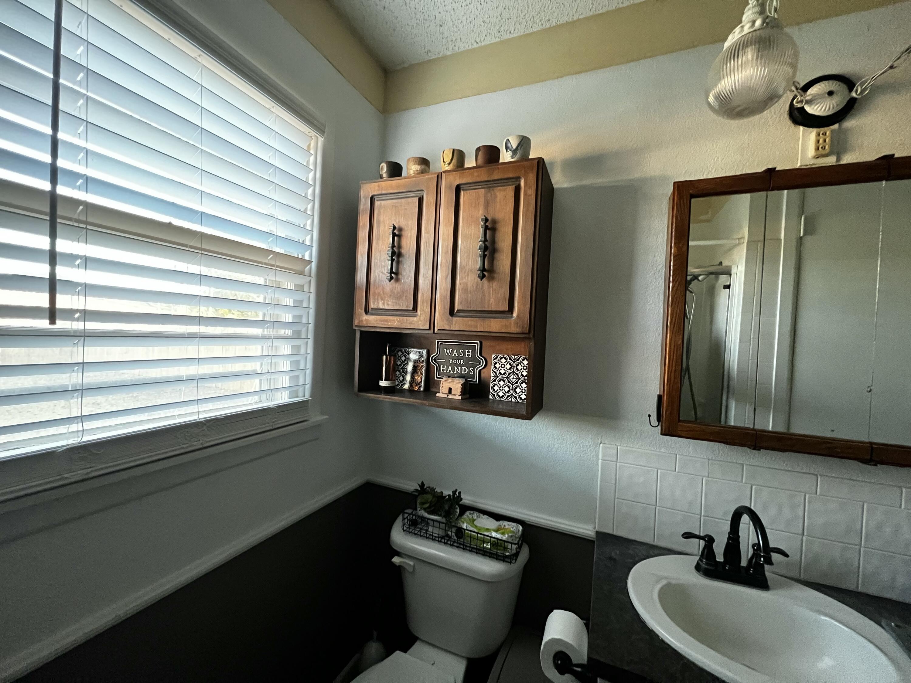 4520 36th Street Lubbock, TX 79414 - Photo 26 of 30 a bathroom with a sink and a mirror