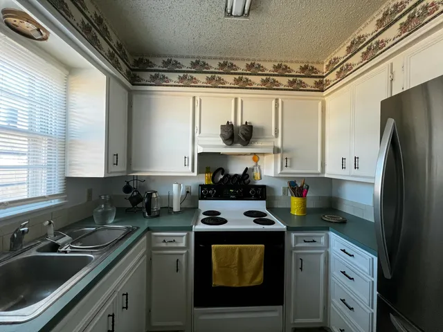 a kitchen with stainless steel appliances granite countertop a refrigerator and a stove