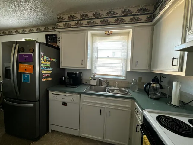 a kitchen with stainless steel appliances granite countertop a refrigerator and a refrigerator