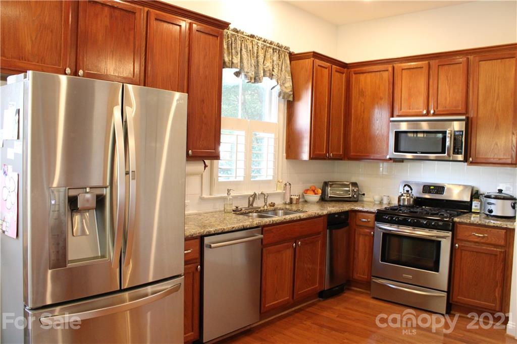 3022 Colonel Springs Way, Unit 171 Fort Mill, SC 29708 - Photo 9 of 30 a kitchen with stainless steel appliances granite countertop a refrigerator stove and sink