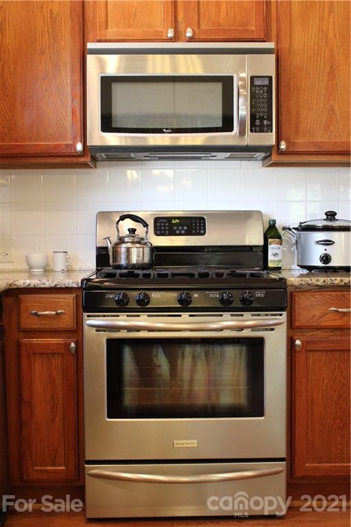 3022 Colonel Springs Way, Unit 171 Fort Mill, SC 29708 - Photo 10 of 30 a kitchen with stainless steel appliances granite countertop a stove microwave and oven