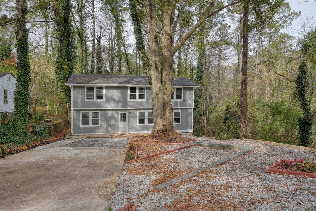 a front view of a house with a yard and trees