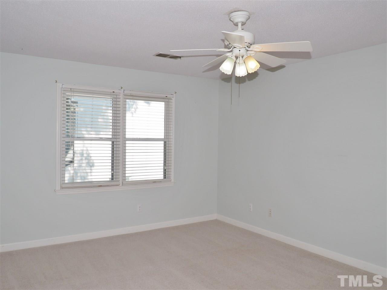 608 Maylands Avenue Raleigh, NC 27615 - Photo 11 of 14 an empty room with windows and chandelier fan