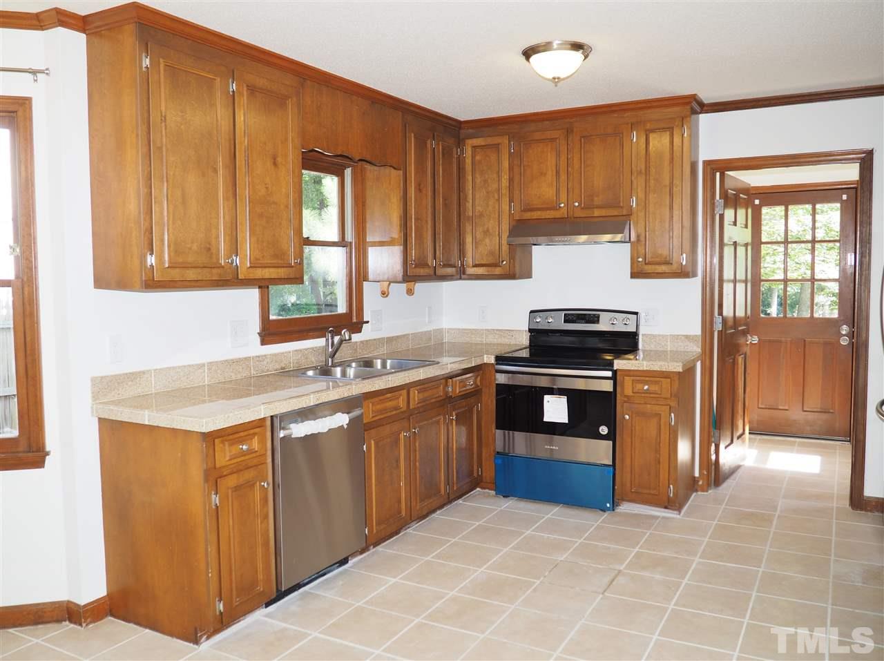 608 Maylands Avenue Raleigh, NC 27615 - Photo 6 of 14 a kitchen with stainless steel appliances granite countertop a stove a sink and a refrigerator