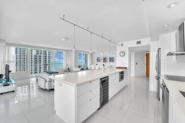 a large white kitchen with stainless steel appliances