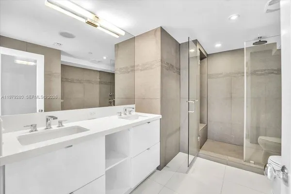 a spacious bathroom with a shower sink mirror and toilet