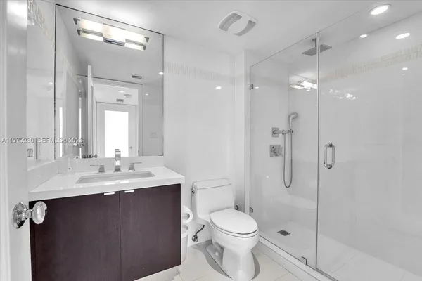 a bathroom with a sink a toilet and shower