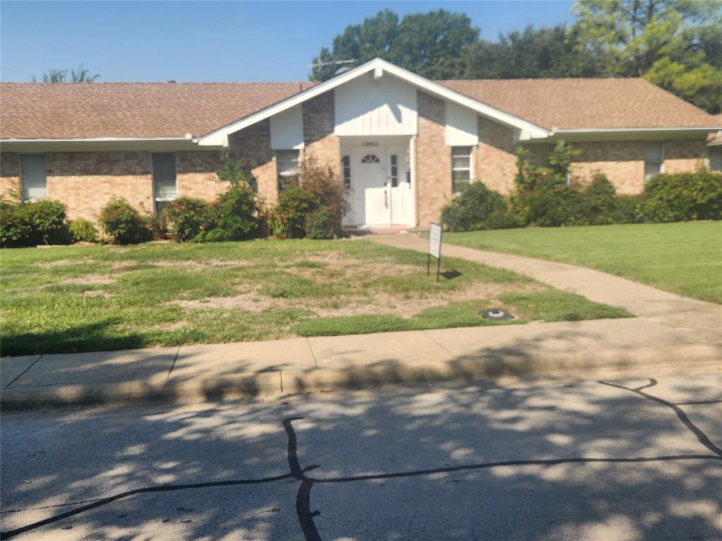 Single story home featuring a front yard, brick siding, and a shingled roof