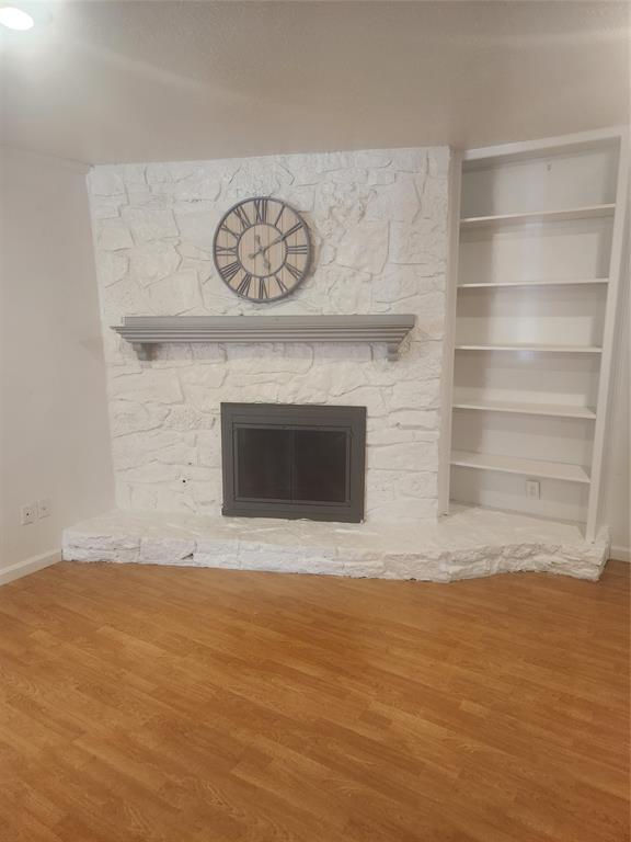 12911 Mitchwin Road Farmers Branch, TX 75234 - Photo 16 of 38 Room details featuring a stone fireplace, built in features, baseboards, and wood finished floors
