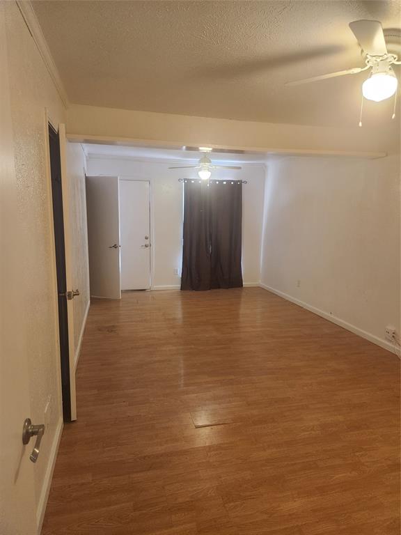 12911 Mitchwin Road Farmers Branch, TX 75234 - Photo 30 of 38 Empty room with baseboards, a textured ceiling, wood finished floors, and a ceiling fan