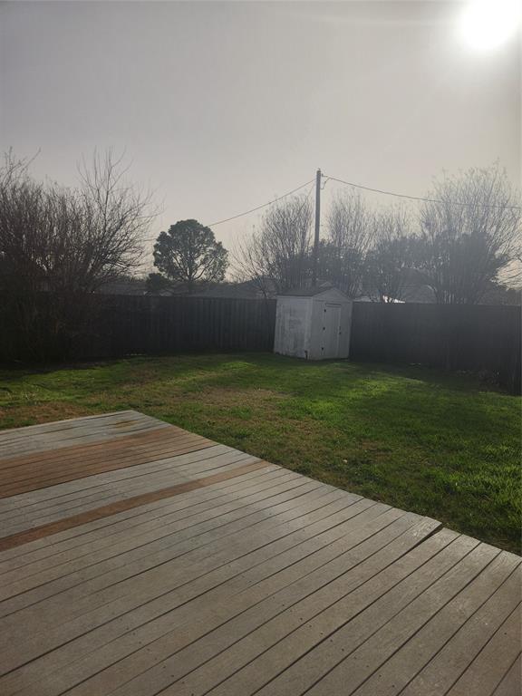 12911 Mitchwin Road Farmers Branch, TX 75234 - Photo 35 of 38 Wooden terrace featuring a yard, an outbuilding, a fenced backyard, and a shed