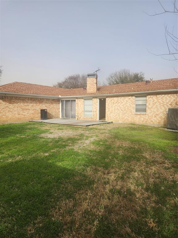 12911 Mitchwin Road Farmers Branch, TX 75234 - Photo 38 of 38 Rear view of property featuring a yard, brick siding, a chimney, and a patio area