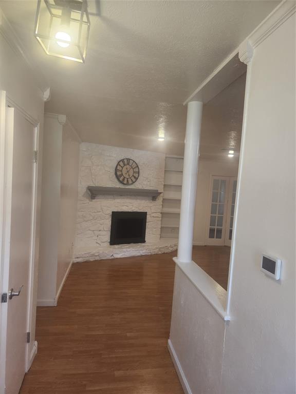 12911 Mitchwin Road Farmers Branch, TX 75234 - Photo 4 of 38 Hallway featuring built in features, a textured ceiling, baseboards, and wood finished floors
