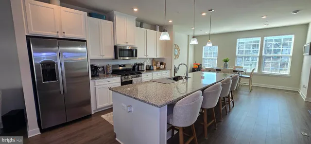 a living room with furniture and a dining table with wooden floor