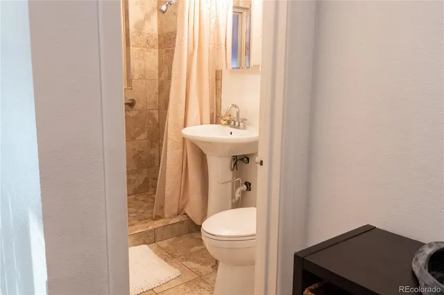 a bathroom with a sink a toilet and shower curtain
