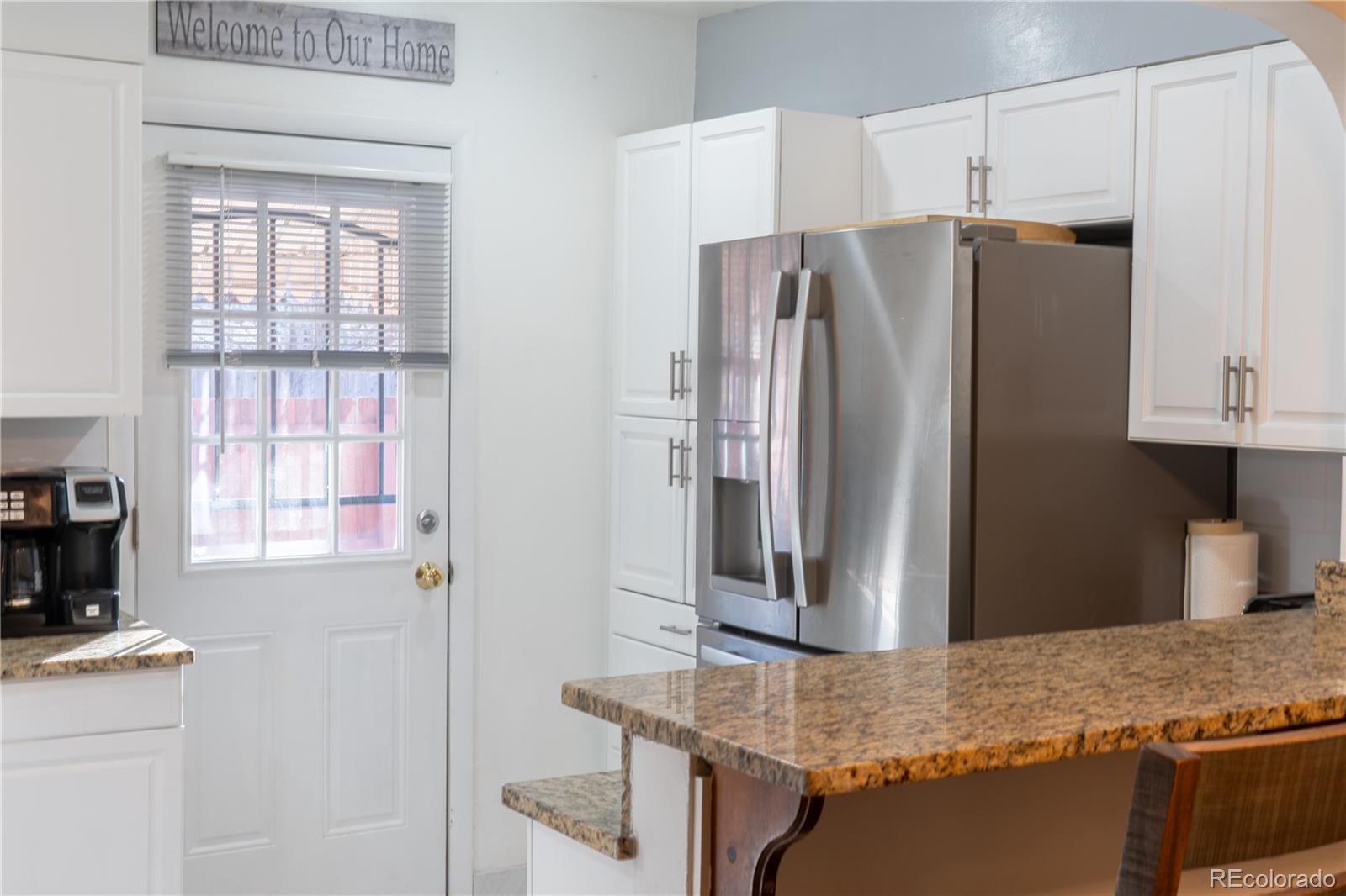 695 South Bryant Street Denver, CO 80219 - Photo 8 of 28 a kitchen with stainless steel appliances granite countertop a refrigerator and a stove