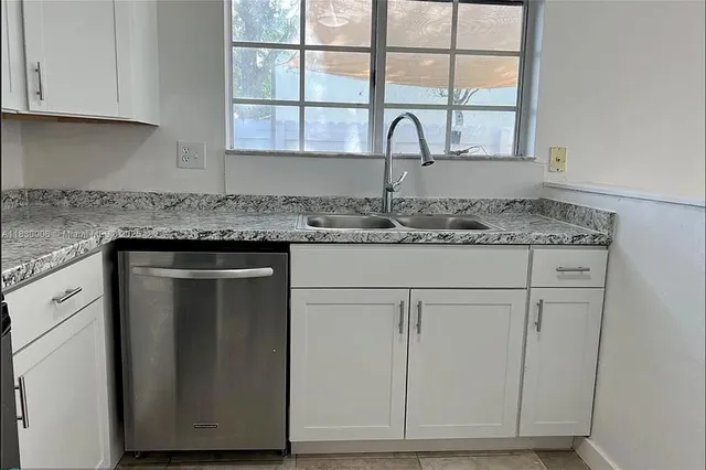 a kitchen with granite countertop cabinets stainless steel appliances and a window
