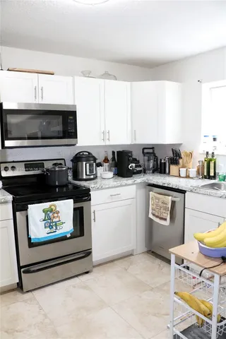 a kitchen with stainless steel appliances a stove a sink and a microwave