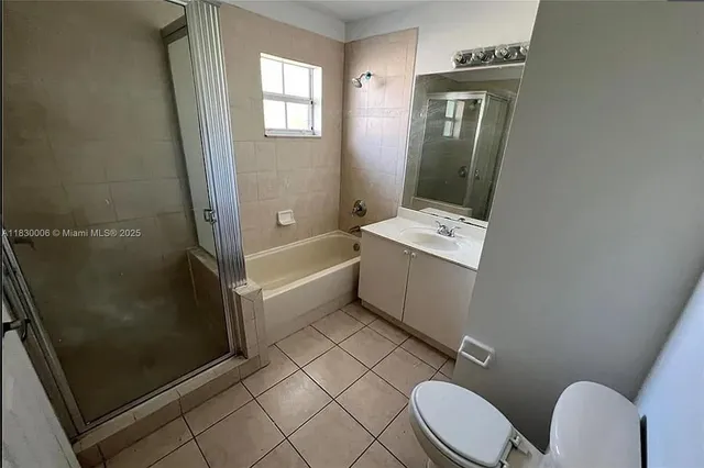 a bathroom with a sink a toilet a mirror and shower