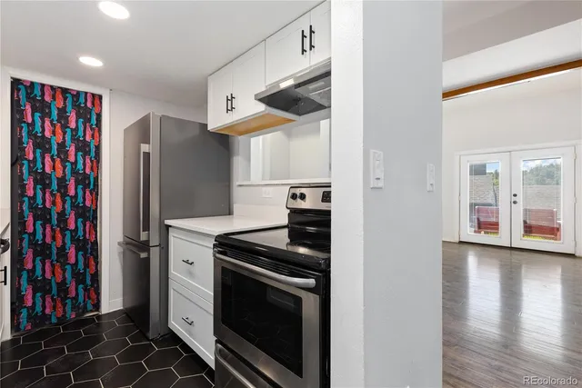 a kitchen with stainless steel appliances granite countertop a stove a refrigerator and a cabinets