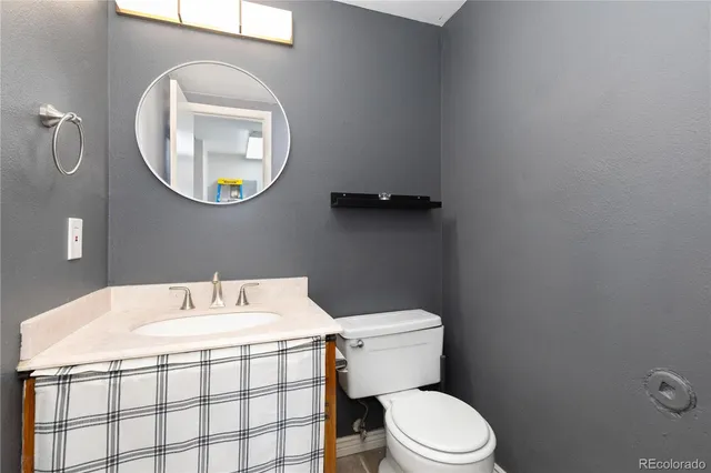 a bathroom with a sink mirror and toilet