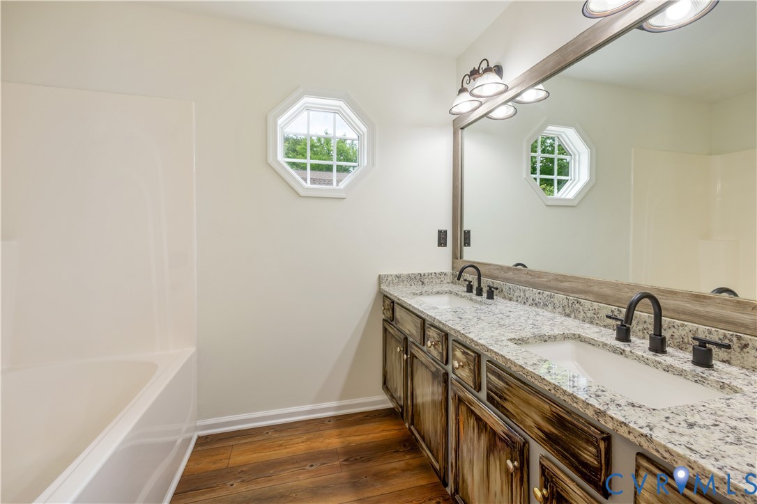5 Walters Way Bumpass, VA 23024 - Photo 13 of 28 a bathroom with a granite countertop sink a large mirror and a window