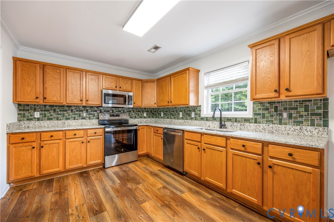 5 Walters Way Bumpass, VA 23024 - Photo 10 of 28 a kitchen with stainless steel appliances granite countertop wooden cabinets a sink and dishwasher with wooden floor