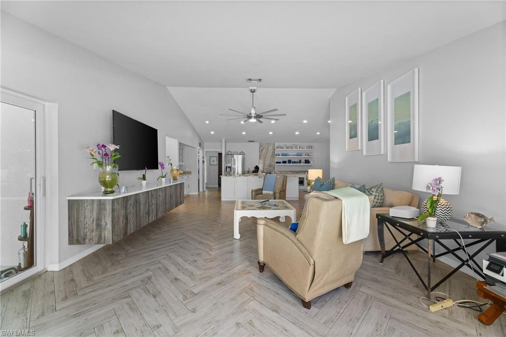 2467 Pinewoods Circle, Unit 3 Naples, FL 34105 - Photo 18 of 33 Living room with lofted ceiling, ceiling fan, and light parquet flooring
